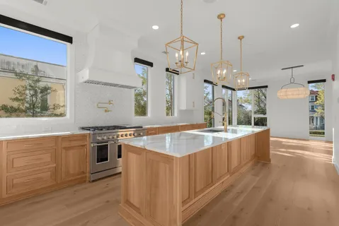 a large kitchen with kitchen island a large island in it