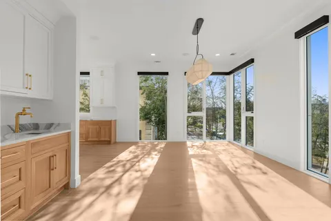 a open kitchen with cabinets a sink and a wooden floor