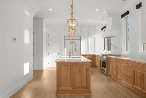 a large kitchen with granite countertop a sink stainless steel appliances and cabinets