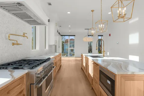 a large kitchen with stainless steel appliances granite countertop a stove and a sink