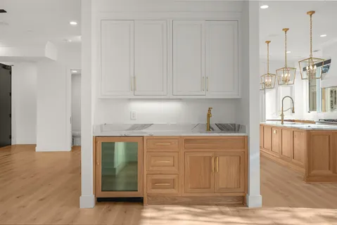 a kitchen with stainless steel appliances granite countertop a sink and cabinets with wooden floor