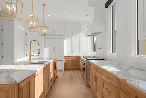 a large kitchen with kitchen island granite countertop a sink and cabinets