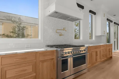 a kitchen with stainless steel appliances wooden floor sink and wooden cabinets