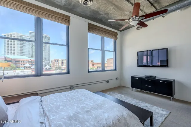 a bedroom with a bed and a dresser next to a window