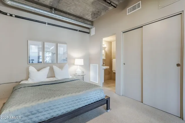 a bedroom with a large bed and a chandelier