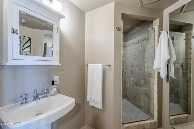 a bathroom with a shower sink and mirror