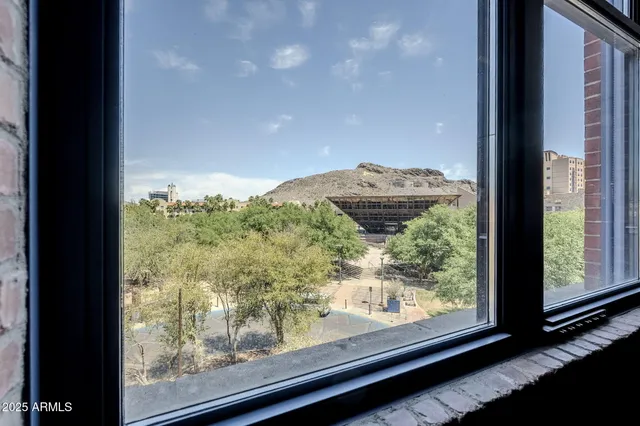 a view of a room with a large window and wooden floor