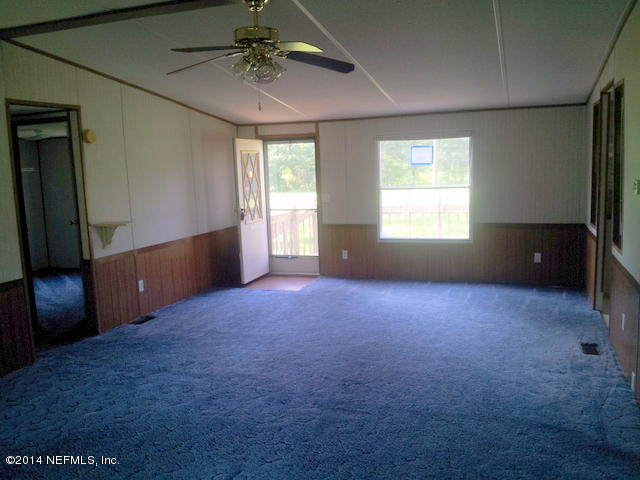 4127 Bronco Road Middleburg, FL 32068 - Photo 2 of 13 an empty room with windows and fan