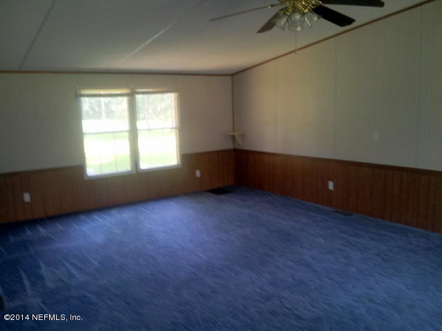 4127 Bronco Road Middleburg, FL 32068 - Photo 3 of 13 an empty room with wooden floor and windows