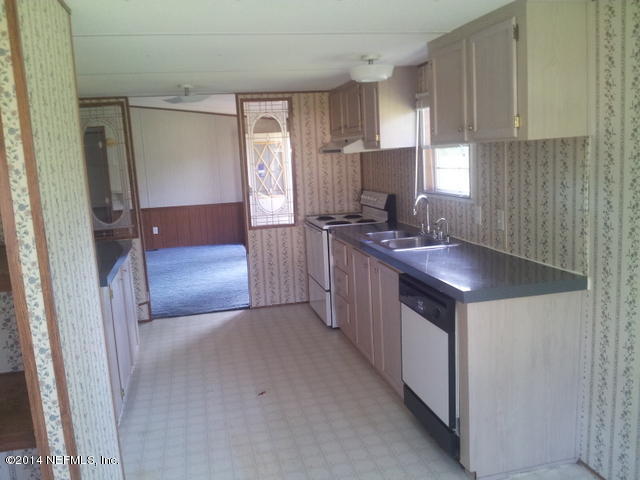 4127 Bronco Road Middleburg, FL 32068 - Photo 7 of 13 a kitchen with stainless steel appliances granite countertop a sink stove and refrigerator