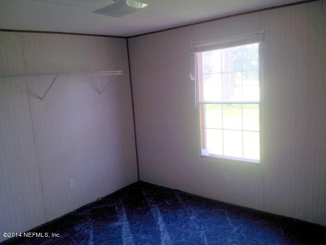 4127 Bronco Road Middleburg, FL 32068 - Photo 8 of 13 an empty room with wooden floor and windows