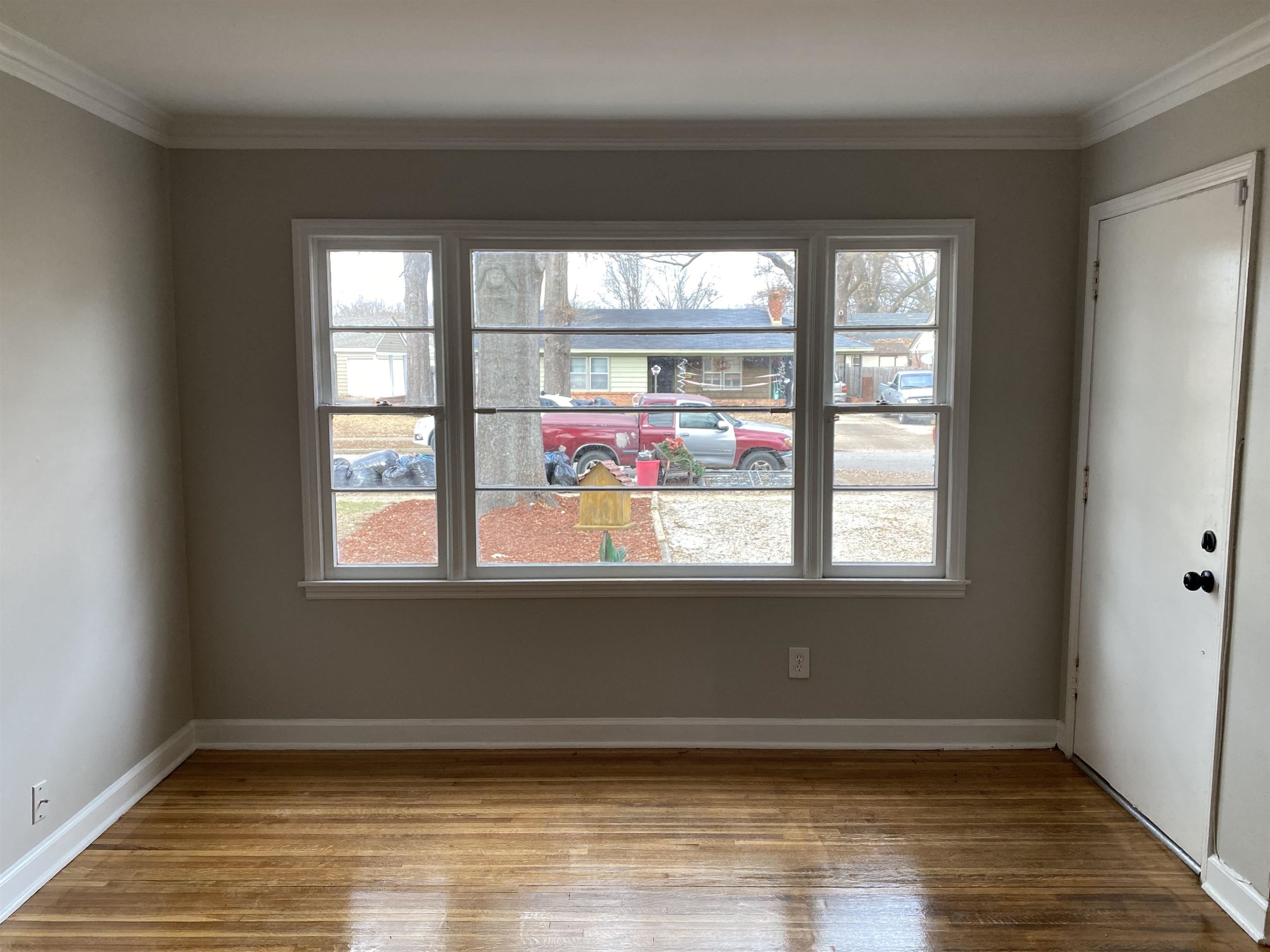 4621 Boyce Road Memphis, TN 38117 - Photo 11 of 25 an empty room with wooden floor and windows