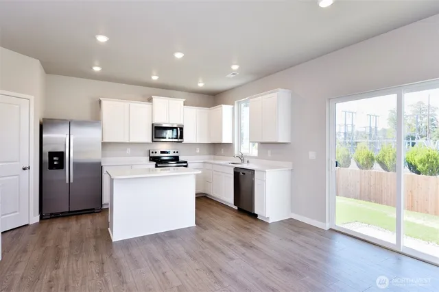 a kitchen with a refrigerator a sink and a stove top oven