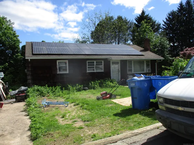 a view of a house with a yard and furniture