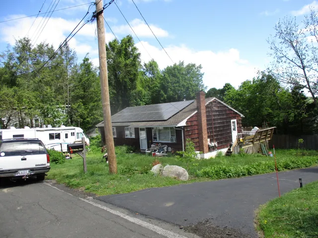 a white house that has a tree in front of it