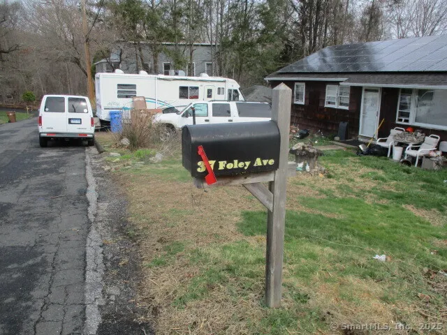 a front view of a house with cars parked