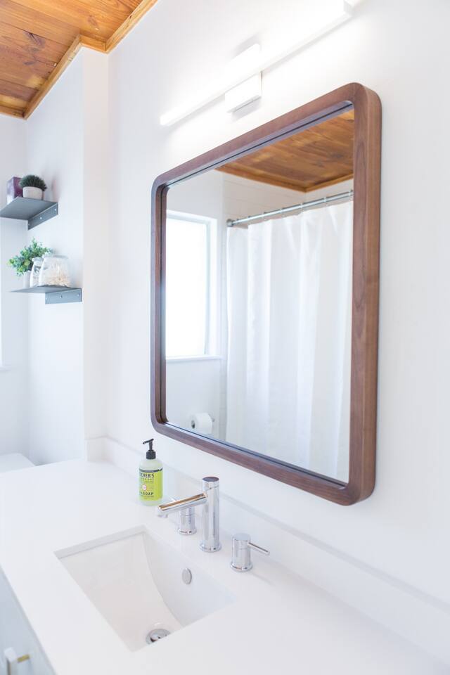 1913 Rabb Road, Unit B Austin, TX 78704 - Photo 7 of 10 A well-lit vanity with a sleek rectangular mirror and elegant fixtures.