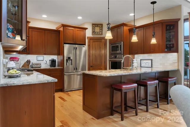 a kitchen with stainless steel appliances granite countertop a stove a sink and a refrigerator