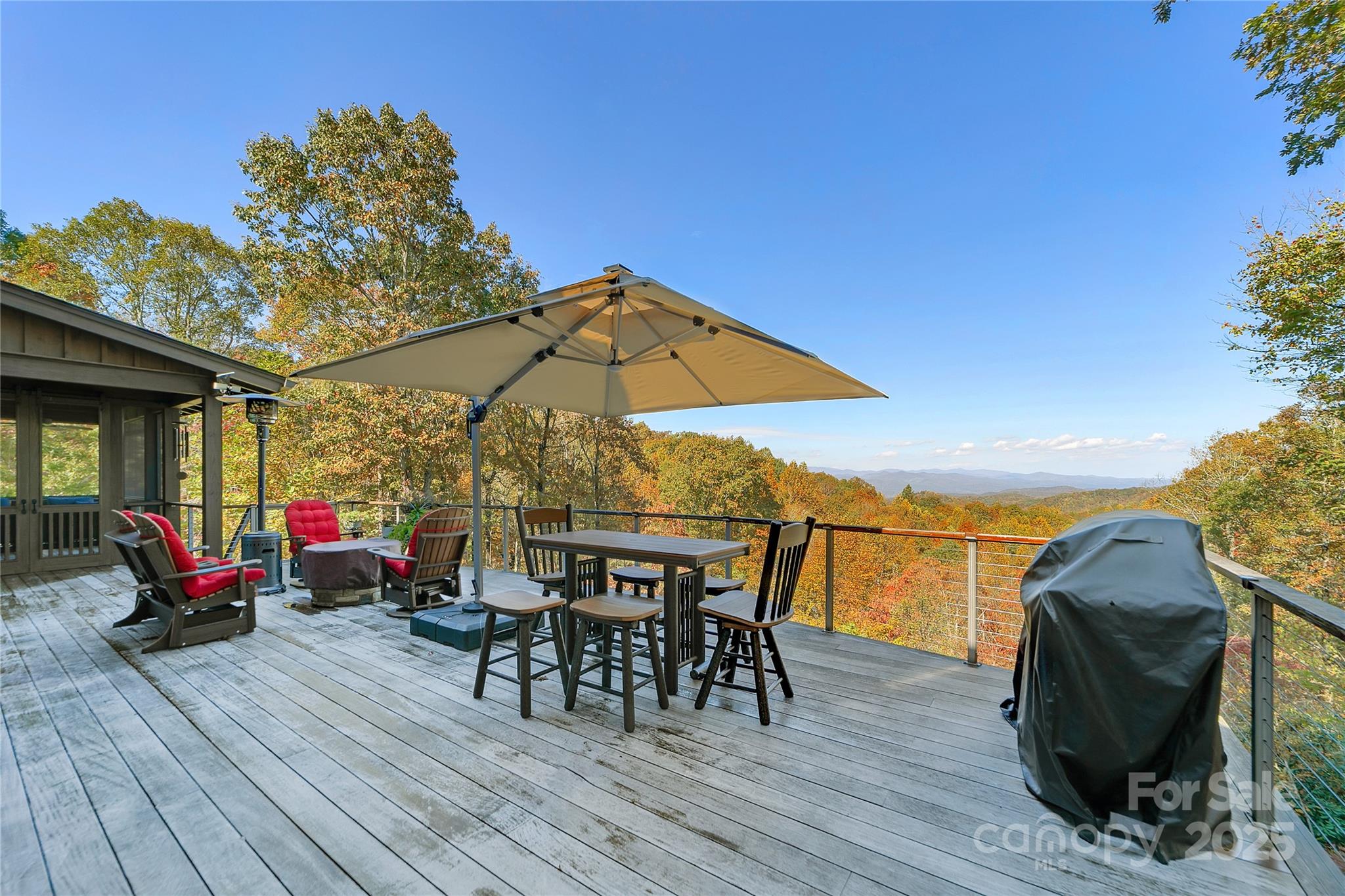 1291 Indian Camp Mountain Road Rosman, NC 28772 - Photo 18 of 48 a view of deck with table and chairs under an umbrella with wooden floor