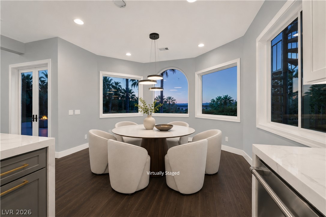 6 Rue Du Ville Henderson, NV 89011 - Photo 7 of 99 “Virtually Staged” This bright dining area offers expansive outdoor views through large windows and features rich hardwood flooring.