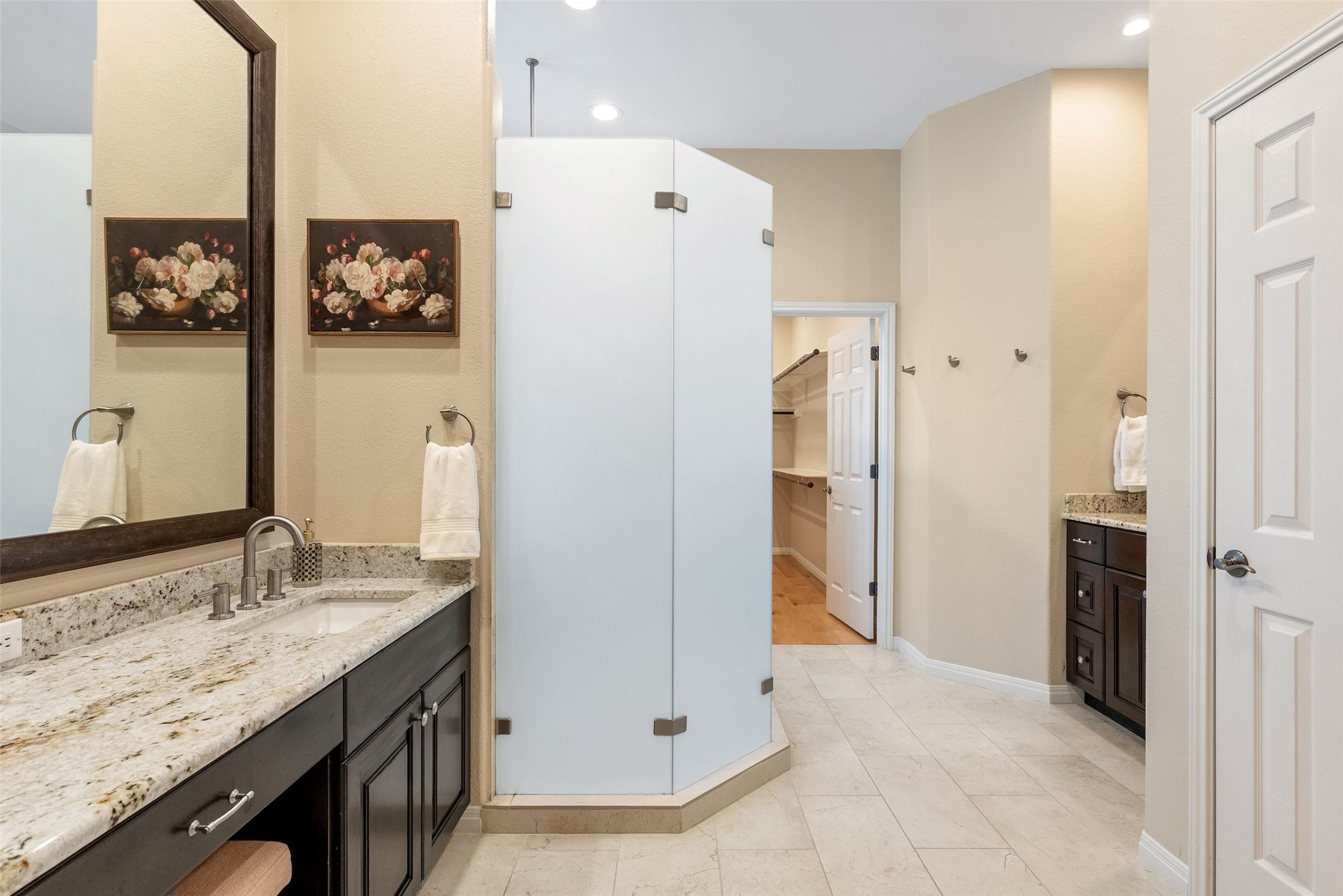 8215 Dark Ridge Cove Austin, TX 78737 - Photo 22 of 40 The large primary en suite bathroom features two separate granite counter vanities, updated cabinetry, a frameless glass walk-in shower, and huge walk-in closet.