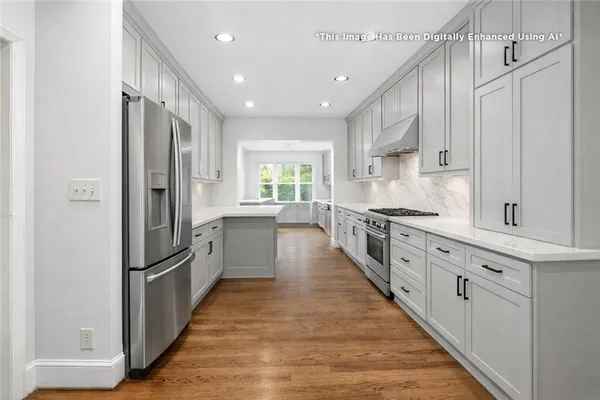 a kitchen with stainless steel appliances kitchen island granite countertop a refrigerator a stove and wooden cabinets