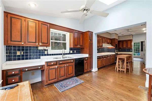 a kitchen with stainless steel appliances granite countertop a sink cabinets and wooden floor