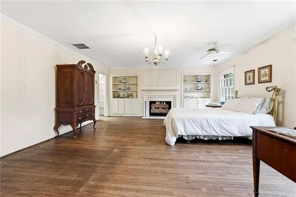 a spacious bedroom with a bed a dresser and windows