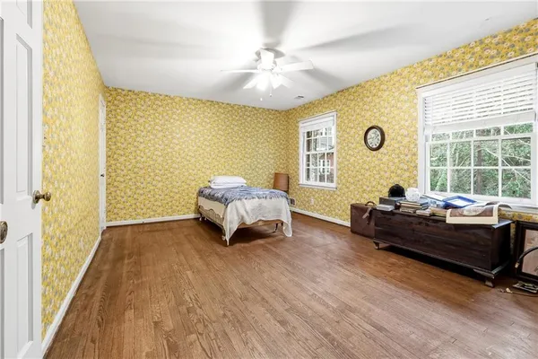 an empty room with wooden floor and ceiling fan