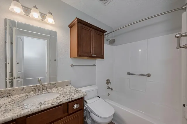 a bathroom with a granite countertop sink toilet and shower