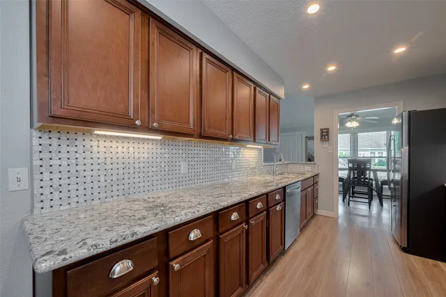 a kitchen with stainless steel appliances granite countertop a sink stove and cabinets