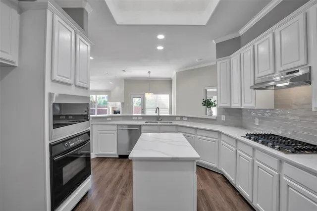 a kitchen with a sink stove top oven and cabinets