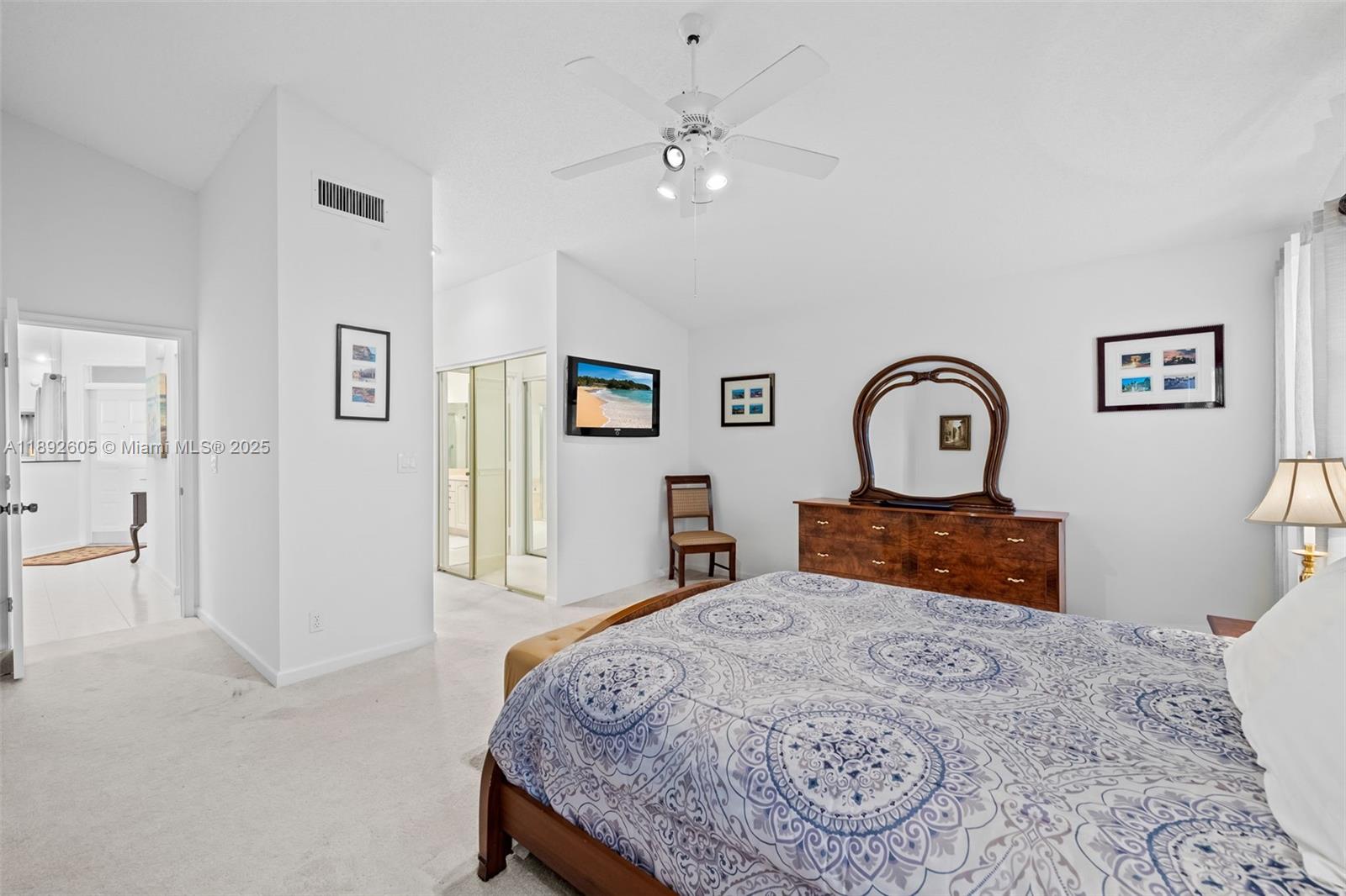 9650 Harbour Lake Circle Boynton Beach, FL 33437 - Photo 16 of 25 a bedroom with a large bed and a chandelier
