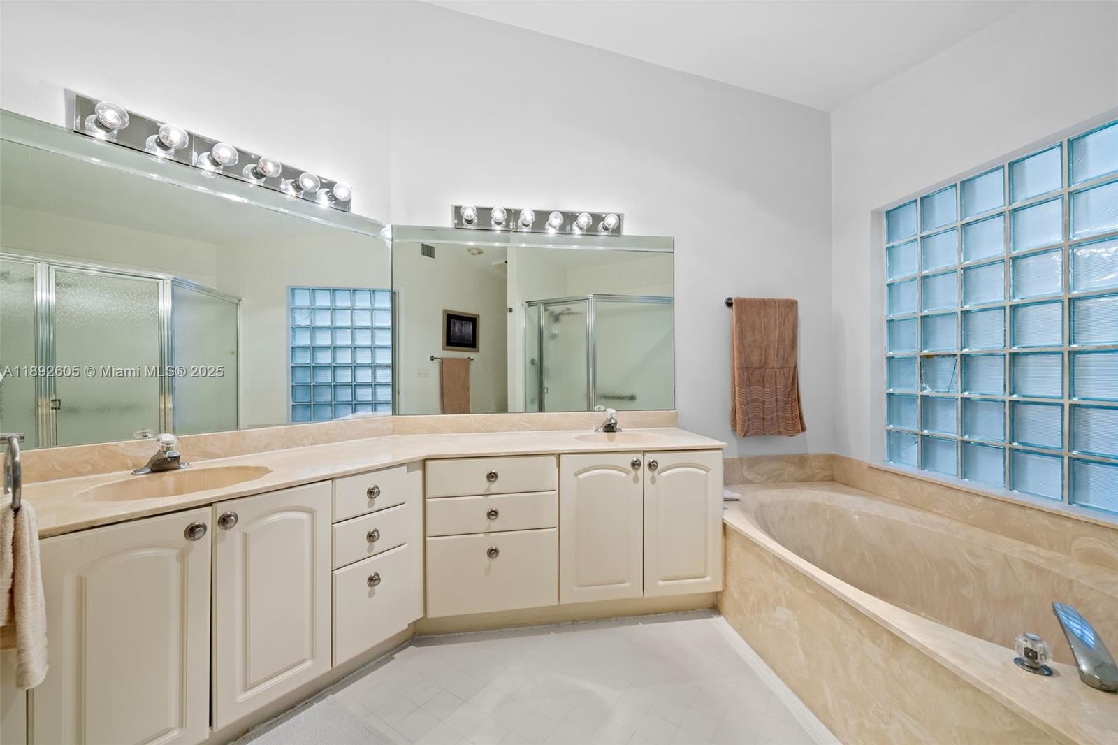 9650 Harbour Lake Circle Boynton Beach, FL 33437 - Photo 19 of 25 a bathroom with a tub a double vanity sink and mirror