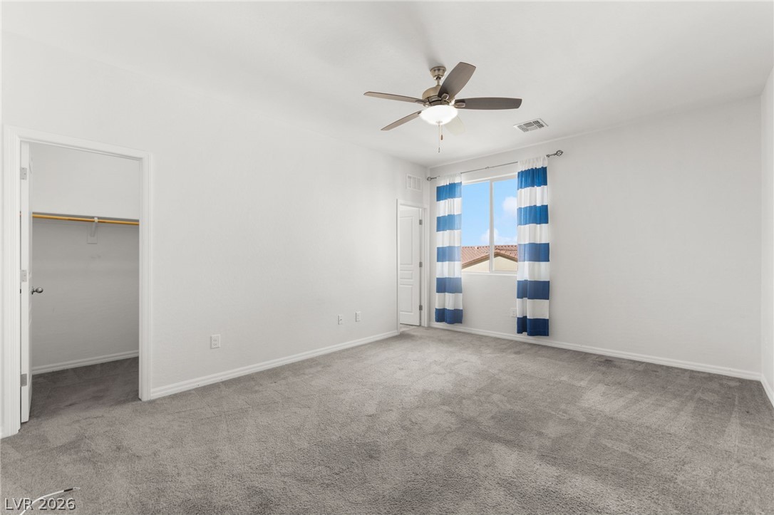 11048 Prairie Grove Road Las Vegas, NV 89179 - Photo 44 of 75 A well-lit bedroom features plush carpeting and a large window providing views of the neighborhood.