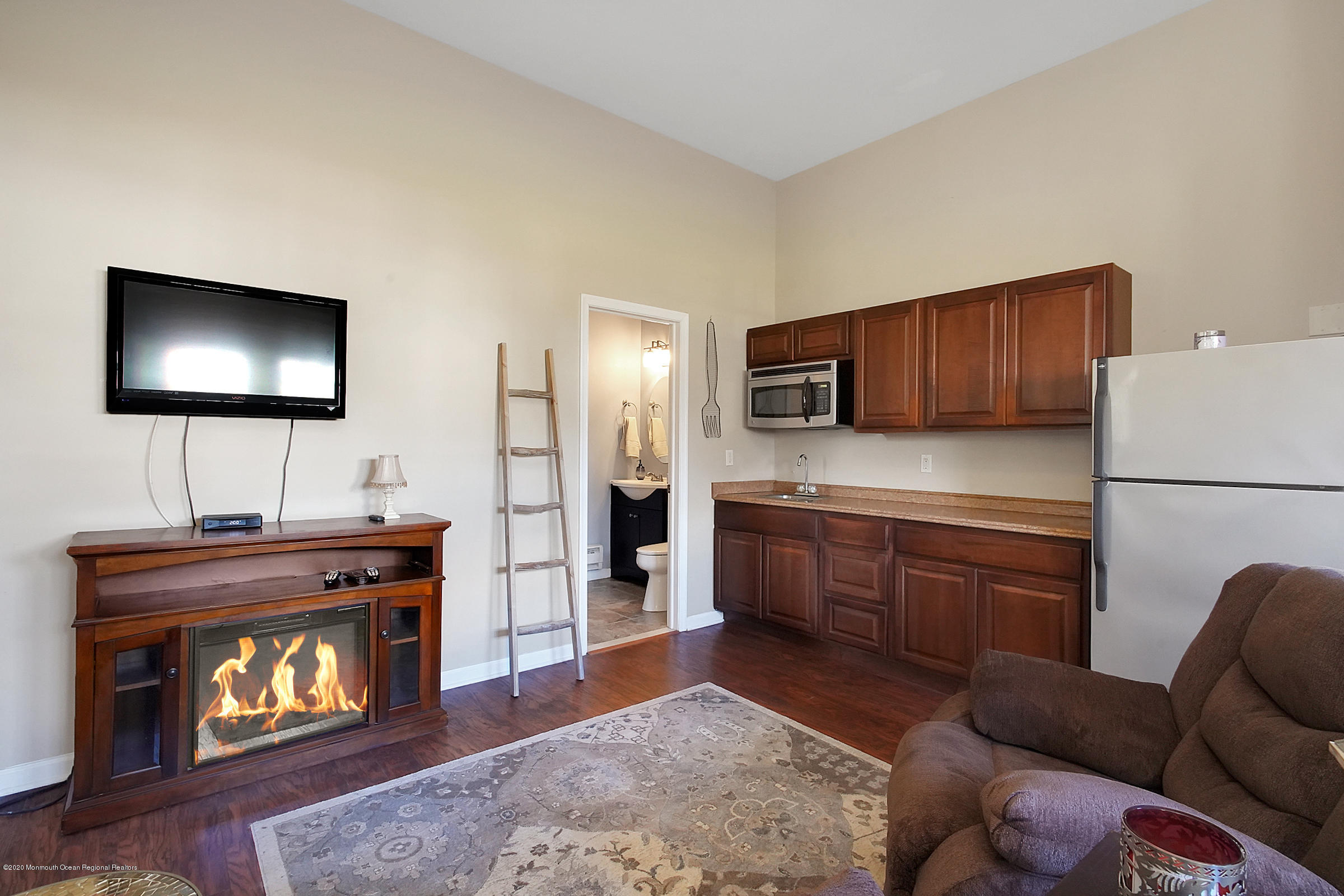 2411 Apple Ridge Circle Manasquan, NJ 08736 - Photo 30 of 37 a kitchen with stainless steel appliances granite countertop a stove top oven a sink dishwasher a refrigerator and a fireplace with wooden floor