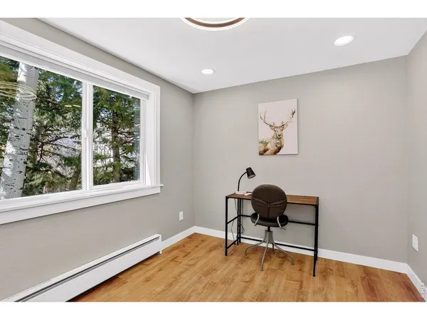 a view of empty room with wooden floor and fan