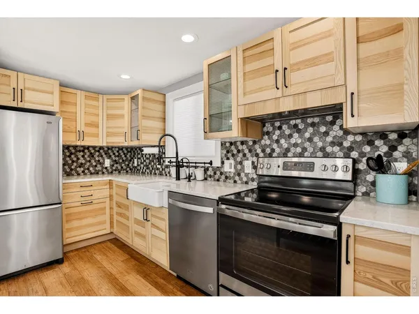 a kitchen with stainless steel appliances a stove a sink and a refrigerator