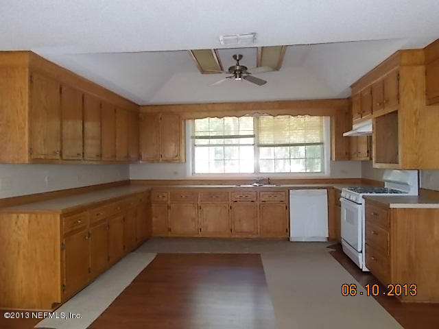 96539 Blackrock Road Yulee, FL 32097 - Photo 24 of 26 a kitchen with kitchen island granite countertop a sink window and cabinets