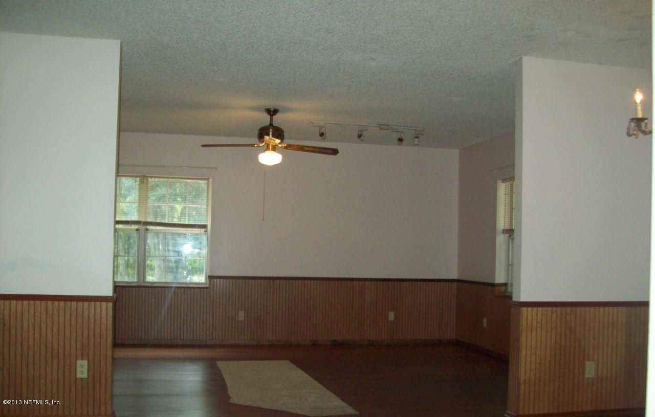 96539 Blackrock Road Yulee, FL 32097 - Photo 3 of 26 an empty room with wooden floor fan and window
