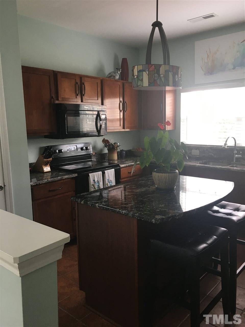 2614 Wyntercrest Lane Durham, NC 27713 - Photo 2 of 19 a kitchen with stainless steel appliances granite countertop a sink a stove and a refrigerator