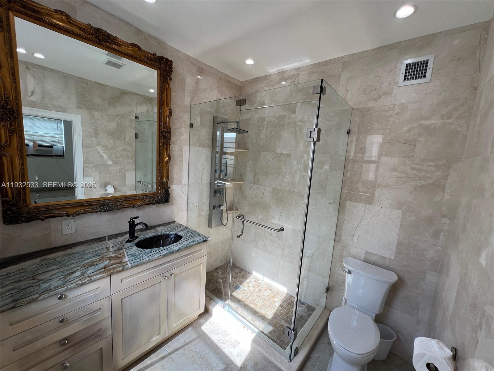 4575 Post Avenue Miami Beach, FL 33140 - Photo 27 of 57 a bathroom with a granite countertop sink toilet and shower