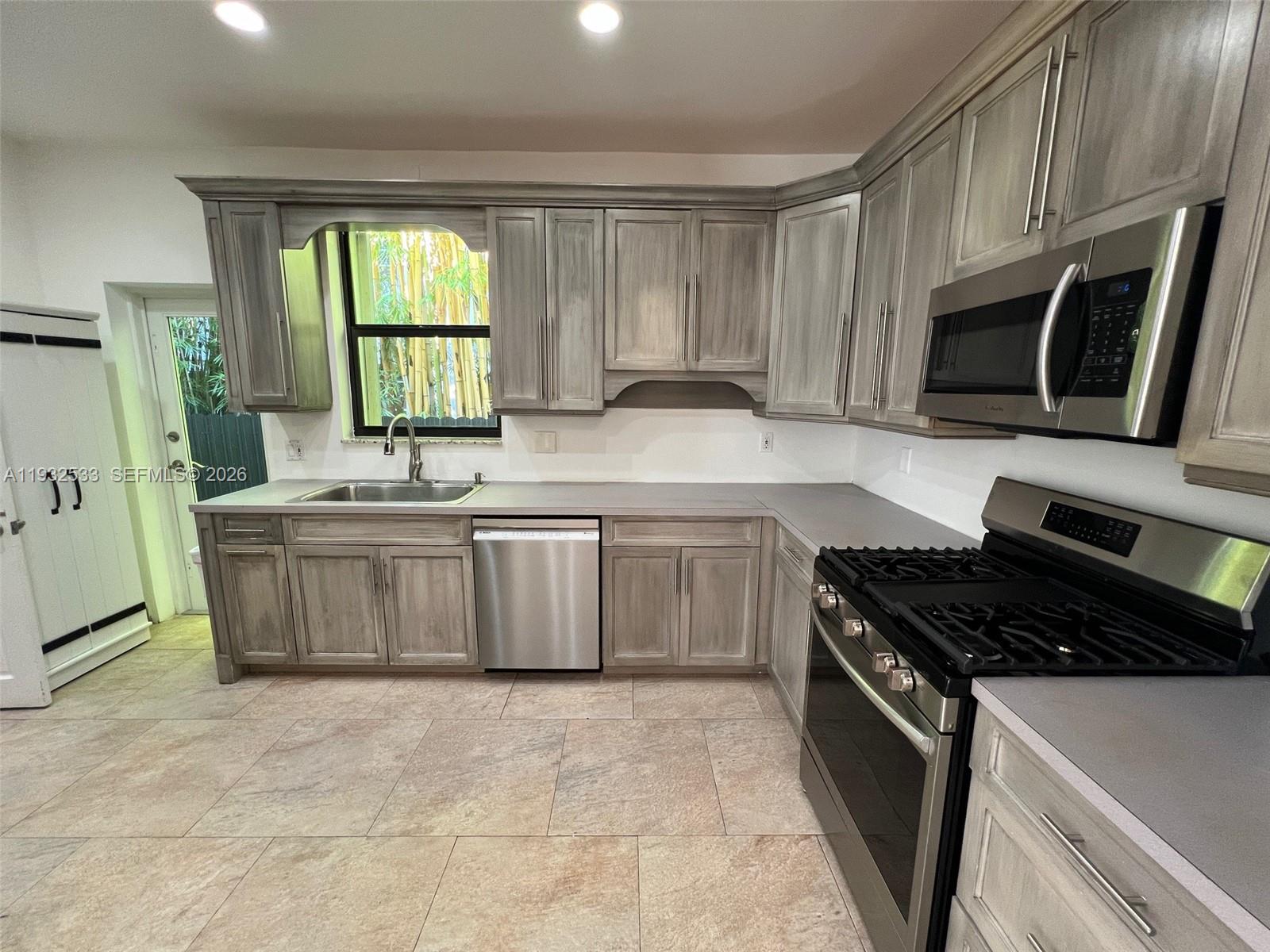 4575 Post Avenue Miami Beach, FL 33140 - Photo 31 of 57 a kitchen with stainless steel appliances a sink stove and cabinets