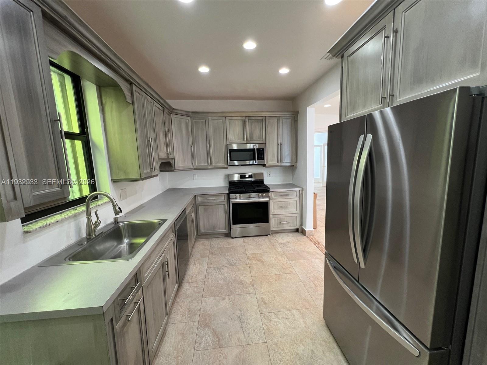 4575 Post Avenue Miami Beach, FL 33140 - Photo 32 of 57 a kitchen with granite countertop a refrigerator and a sink