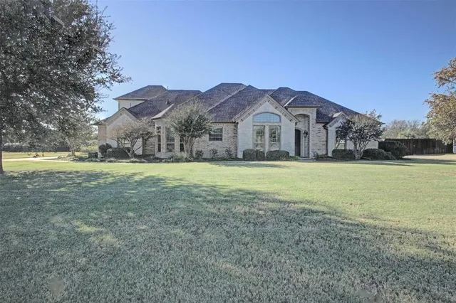 a view of a big house with a big yard and palm trees