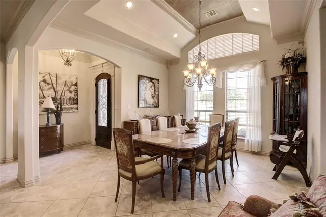 a view of a a dining room with furniture and chandelier