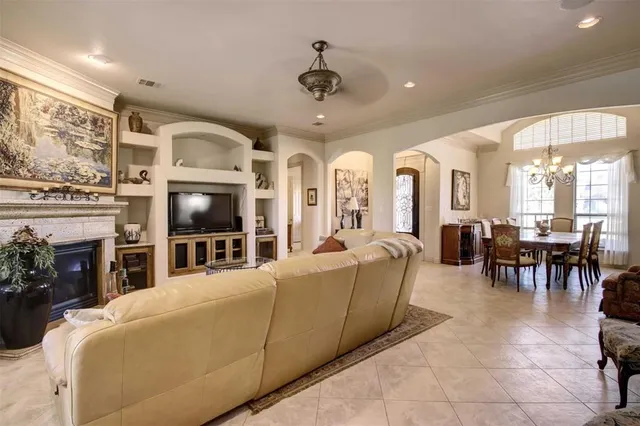 a living room with furniture a fireplace and a chandelier