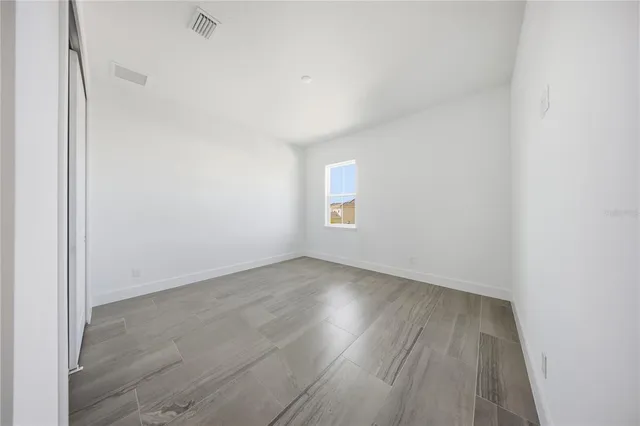 a large white bedroom with a large window and chandelier