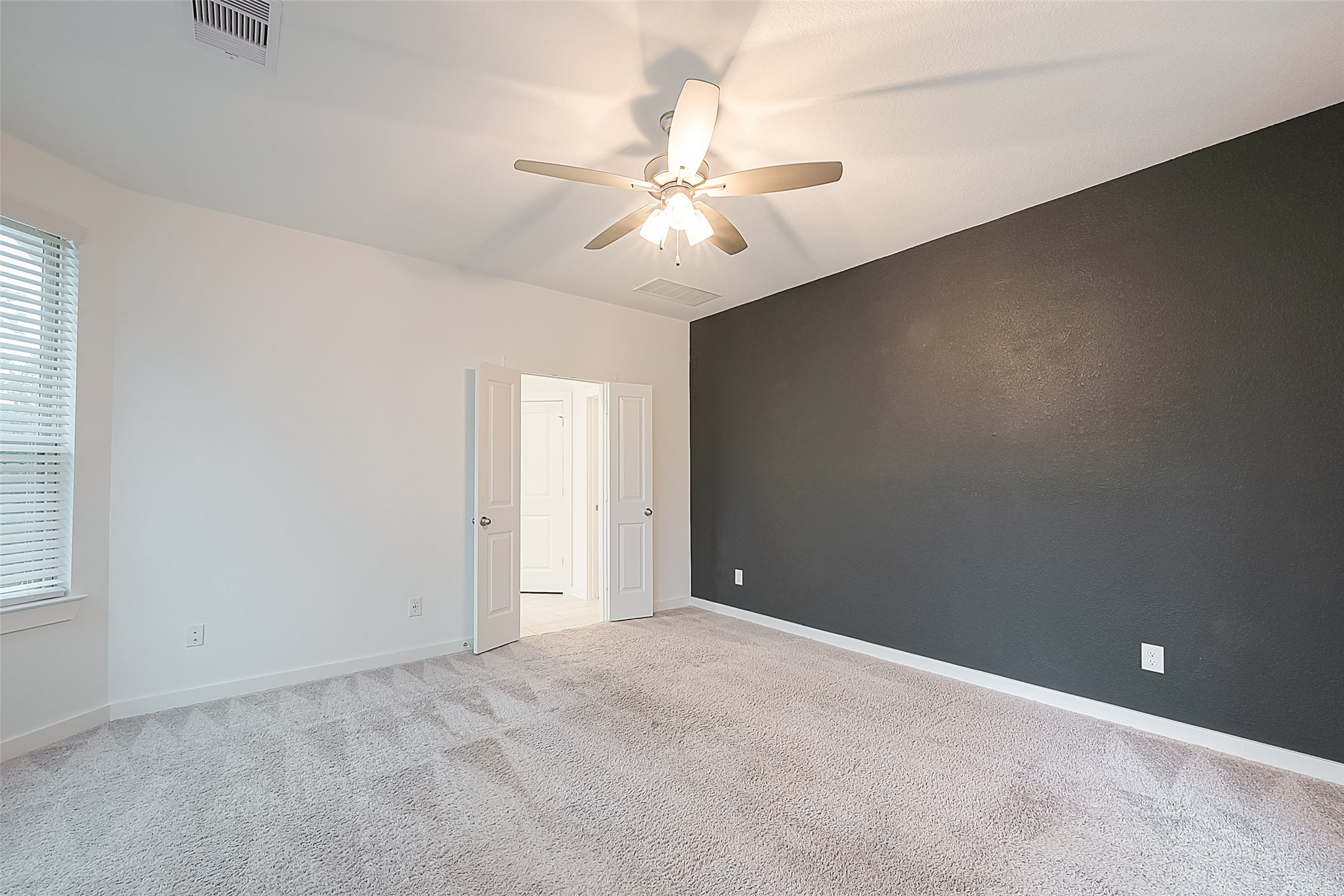 516 Timber Voyage Court Conroe, TX 77304 - Photo 14 of 25 an empty room with a chandelier fan and windows