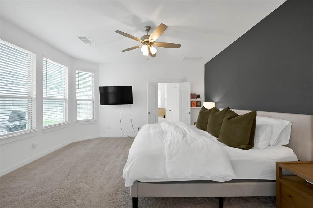 516 Timber Voyage Court Conroe, TX 77304 - Photo 15 of 25 a living room with a bed furniture and a flat screen tv